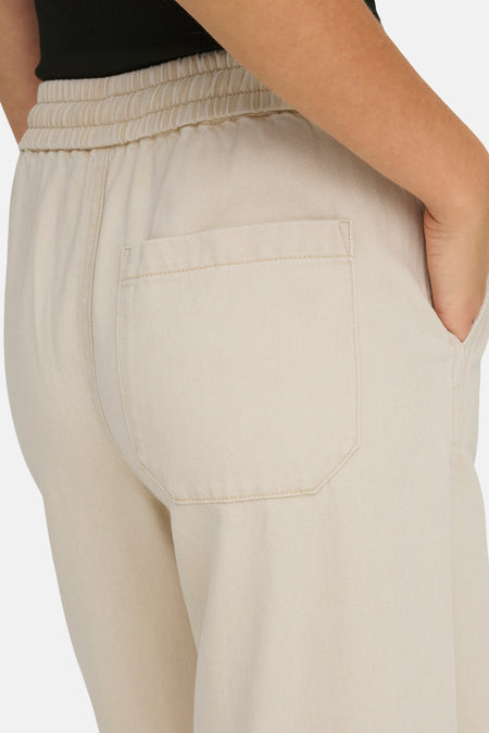 Ecru broek van ONLY, met elastische tailleband en achterzak, close-up.