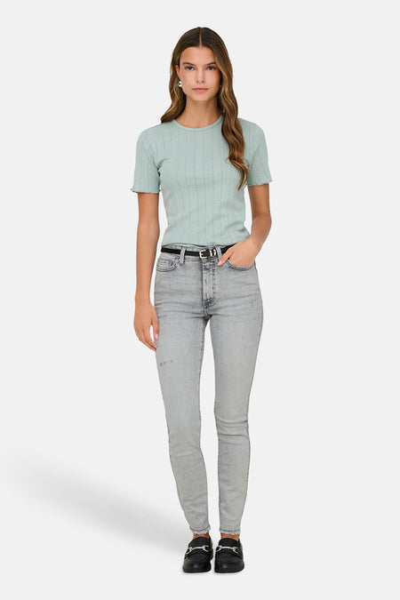 Groen T-shirt met korte mouwen van ONLY®, gedragen met een lichtgrijze jeans en zwarte loafers.