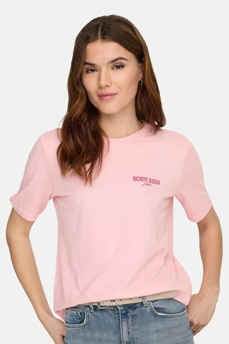T-shirt rose à manches courtes ONLY®, avec petit imprimé texte sur la poitrine, porté avec un jean et une ceinture.