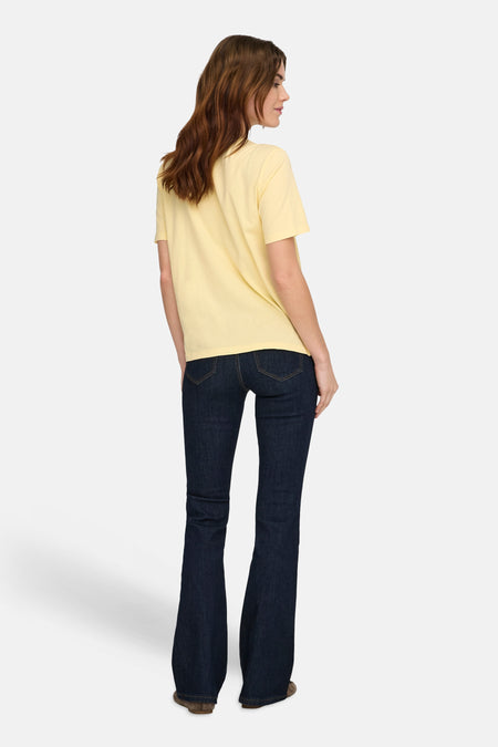 Geel T-shirt met korte mouwen van ONLY®, achterkant van een vrouw in donkere flare jeans.
