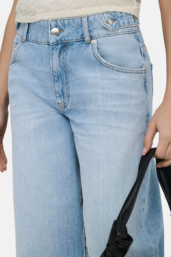 Jeans large en denim bleu clair de ONLY, avec passants de ceinture et poches avant, combiné avec un haut blanc.