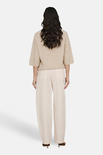 Pantalon écru de JDY, vu de dos, combiné avec un pull beige et des talons marron.