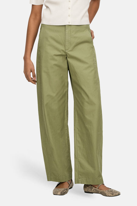 Groene broek van JDY, met wijde pijpen en gedragen met een crèmekleurige top en slangenleren ballerina's.
