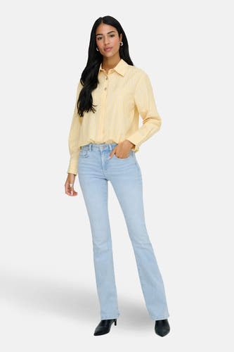 Geel, lange mouwen hemd van JDY, met een gestreept patroon, gedragen met lichte jeans en zwarte laarzen.
