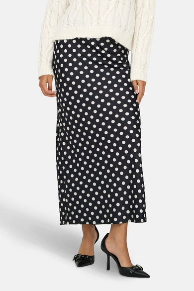 Robe noire d'ONLY, avec des taches blanches, portée avec un pull blanc et des baskets noires, vue de dos.
