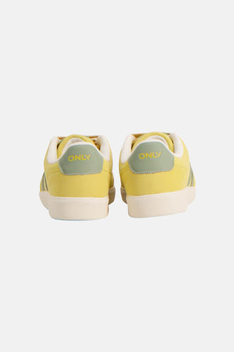 Gele sneakers van ONLY met beige zool en groene accenten op de achterkant.