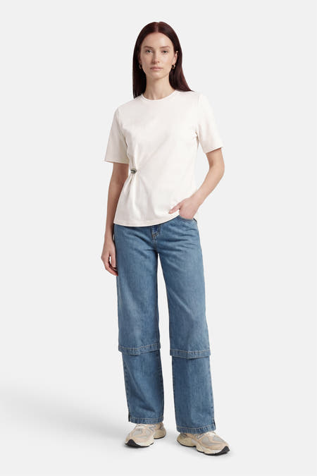 Wit T-shirt met korte mouwen van ONLY, met een decoratieve speld aan de zijkant en gecombineerd met wijde jeans.