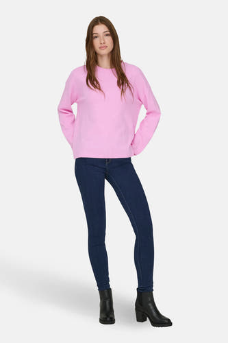 Roze trui met ronde hals van ONLY®, gedragen met donkere jeans en zwarte enkellaarsjes met hak.