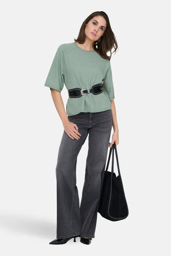 Groene trui met ronde hals van ONLY, gedragen met een zwarte riem en grijze jeans, met een zwarte tas.
