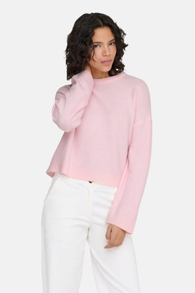 Roze trui met ronde hals van ONLY, gedragen met witte broek.