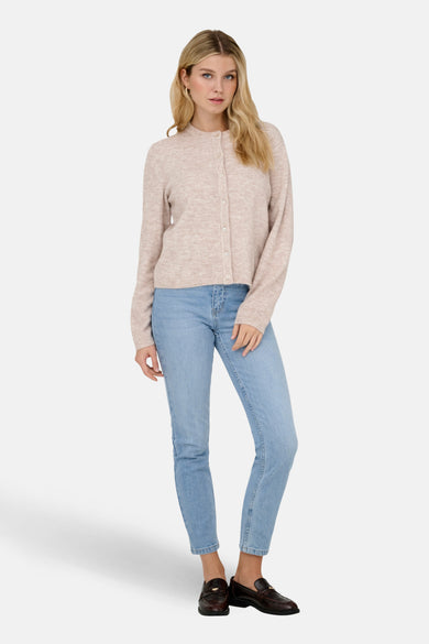 Beige vest van ONLY, met knoopsluiting, gecombineerd met een blauwe jeans en donkerbruine loafers.
