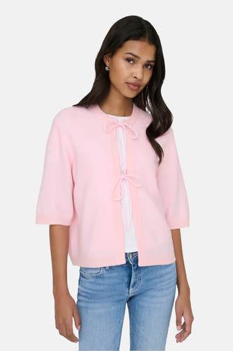Veste rose de ONLY®, avec fermeture éclair et manches trois-quarts, associée à un shirt blanc et des jeans.