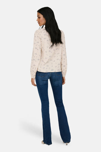 Ecrukleurig hemd met lange mouwen van ONLY®, met een fijn bloemenpatroon, gedragen met jeans met uitlopende pijpen.
