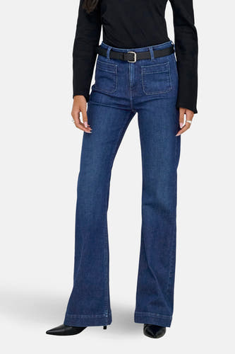 Jean flare bleu marine de ONLY, avec ce ce et des poches brodées, associé à une chemise noire et des chaussures noires.