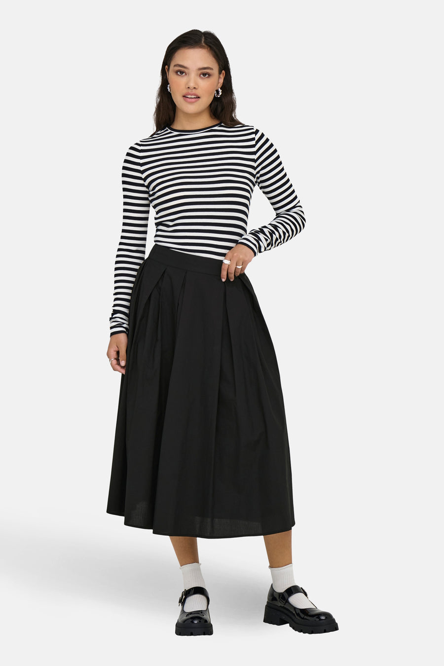 Jupe longue noire de ONLY, avec des plis et combinée avec un haut rayé et des chaussures à plateforme.