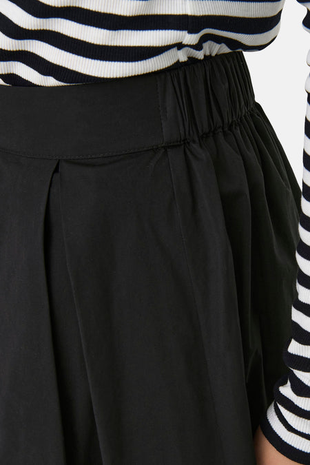 Zwarte lange rok van ONLY, met elastische tailleband en subtiele plooien, gecombineerd met een gestreepte top.
