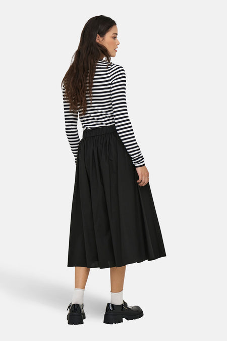 Zwarte lange rok van ONLY, gecombineerd met een gestreepte top en plateauzool schoenen met witte sokken.