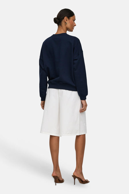 Witte short van JDY, met wijde pijpen, een crêpe textuur en op de knie lengte, gezien van achteren.
