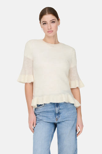 T-shirt écru de ONLY®, avec des manches courtes et un col plié, associé à un jeans bleu et des chaussures noires.