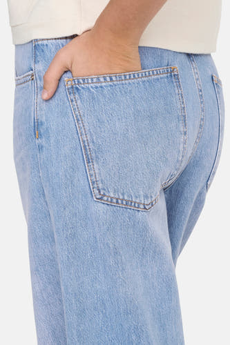 Jean spécial fit en denim bleu clair d'ONLY, avec la main dans le sac arrière.