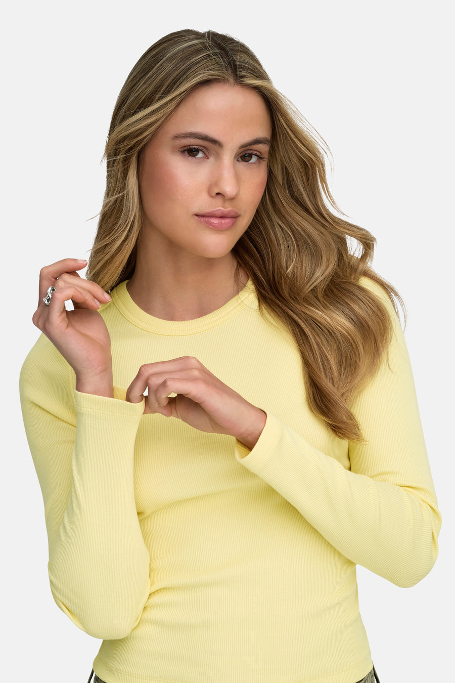 T-shirt jaune à manches longues de ONLY, avec une structure en côtes et un modèle aux cheveux blonds longs.