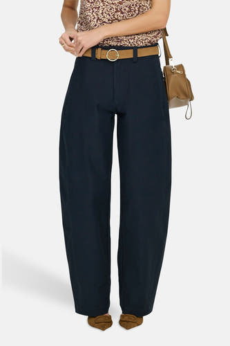 Chino bleu d'ONLY, avec une ceinture marron et combiné avec un chemisier et des chaussures marron.