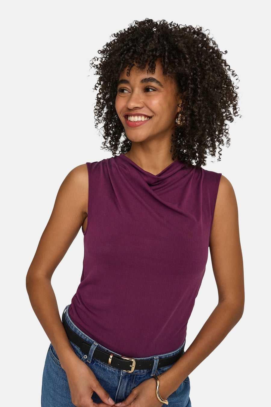 Paarse mouwloze top van ONLY® met gedrapeerde halslijn, gedragen door een glimlachende vrouw met een spijkerbroek en zwarte riem.