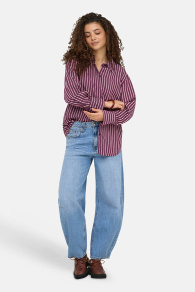 Paars hemd met lange mouwen van ONLY® met lichtroze verticale strepen, gecombineerd met wijde jeans.