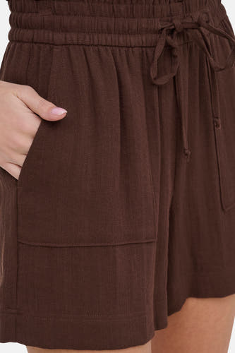Bruine korte broek van JDY met elastische tailleband en trekkoord, voorzien van zakken, close-up van model