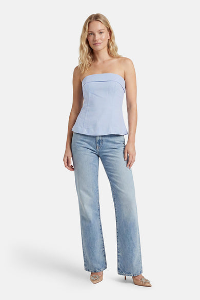 Lichtblauwe mouwloze blouse van ONLY® met peplumzoom, gedragen met lichtblauwe jeans en goudkleurige hakken, front view