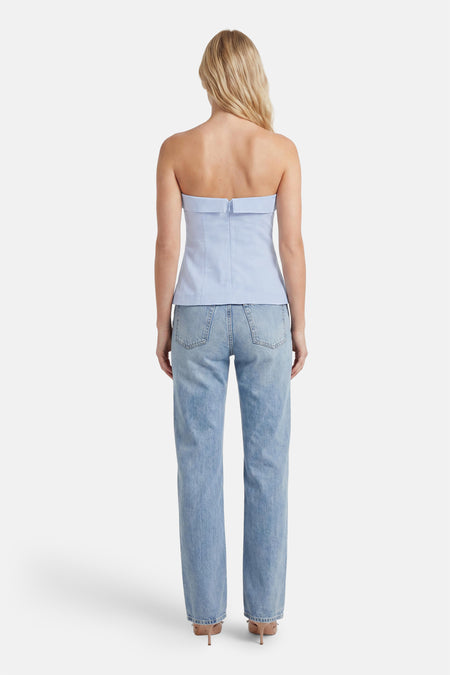 Lichtblauwe mouwloze blouse van ONLY®, strakke pasvorm met rits aan de rug, gedragen met lichtblauwe jeans en hoge hakken, achterkant weergegeven
