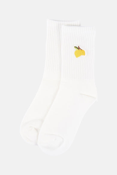 Chaussettes blanches ONLY avec une fleur jaune brodée.