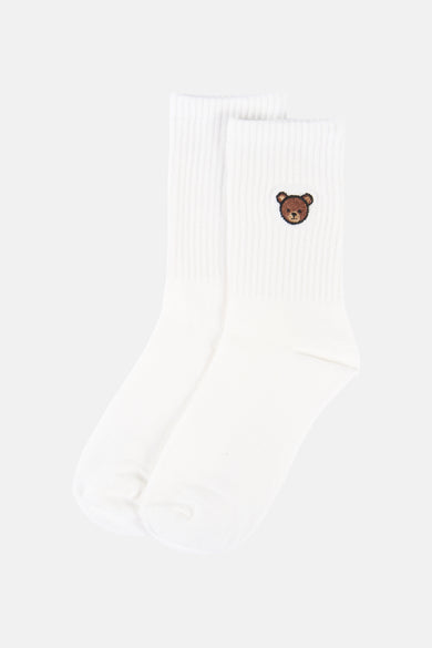 Chaussettes blanches d'ONLY Essentials, avec un petit ours brun brodé.