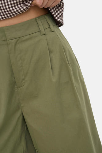 Olijfgroene korte broek van ONLY® met zakken en elastische taille, gedragen met geruit overhemd, close-up van voorkant