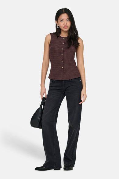 Bruin gilet van ONLY, met knoopsluiting aan de voorkant, gecombineerd met een zwarte handtas en donkere jeans.