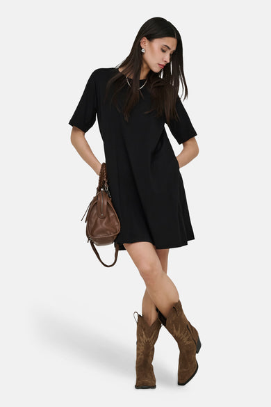 Robe noire à manches courtes de ONLY, avec sac marron et bottes de cowboy.