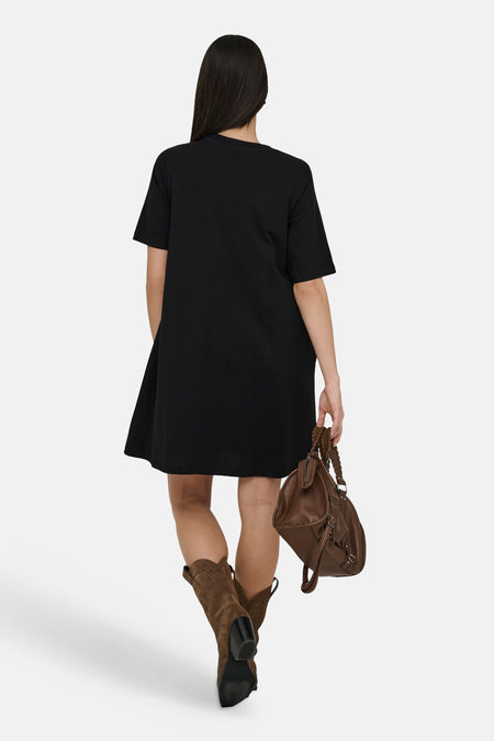 Robe noire à manches courtes de ONLY, coupe décontractée, associée à des bottes marron et un sac marron.