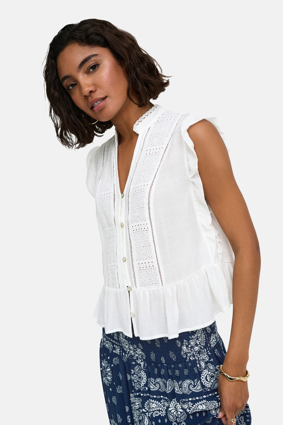 Witte mouwloze blouse met kantdetails en ruches van ONLY®, voorzien van knoopsluiting en zijdelingse pasvorm, gedragen met een blauwe printrok.