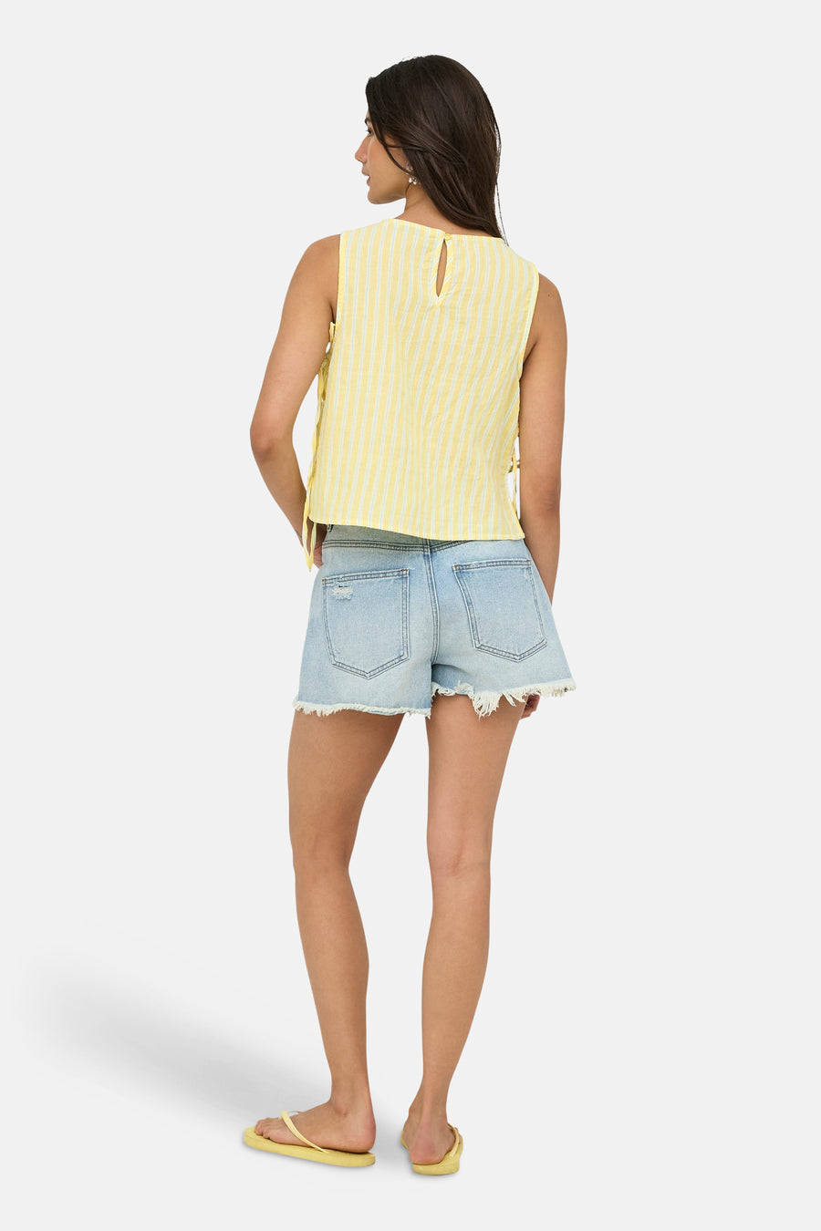 Gele gestreepte mouwloze blouse van ONLY® met sleutelgatdetail aan de achterkant, gedragen met denim shorts en gele teenslippers.
