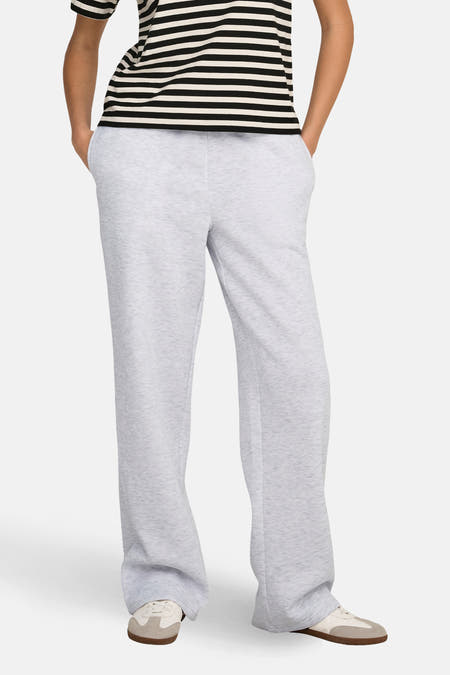 Pantalon de jogging gris d'ONLY, à jambes larges et combiné avec un t-shirt rayé et des baskets.