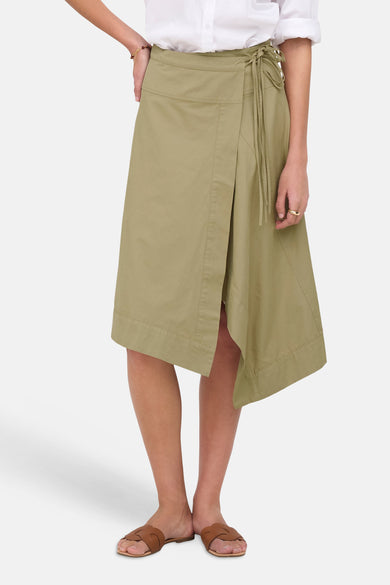 Olijfgroene 3/4 rok van JDY met wrapdetail en zijdelingse strik, gedragen met wit overhemd en bruine slippers, front view