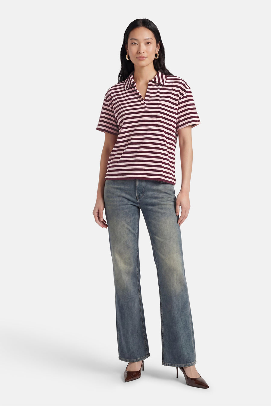 Polo met korte mouwen in roze en bordeaux gestreept patroon van JDY, met kraag, V-hals en borstzak, gedragen met blauwe jeans.