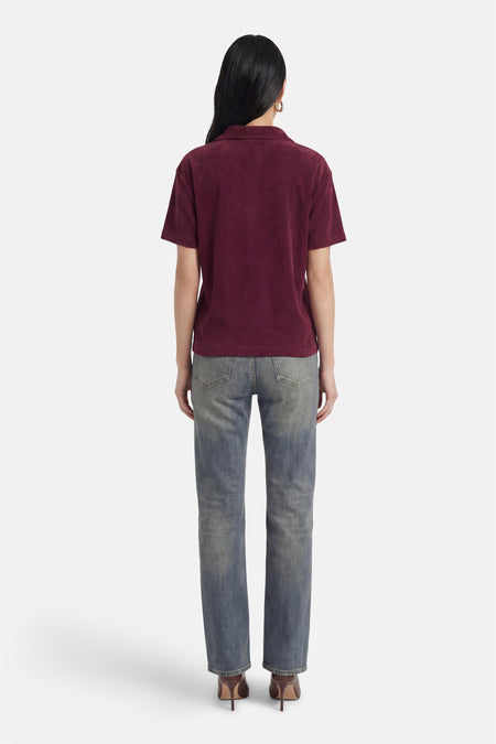 Paarse polo met korte mouwen van JDY, met zachte textuur, gezien vanaf de rug, gedragen met jeans en bruine hakken.