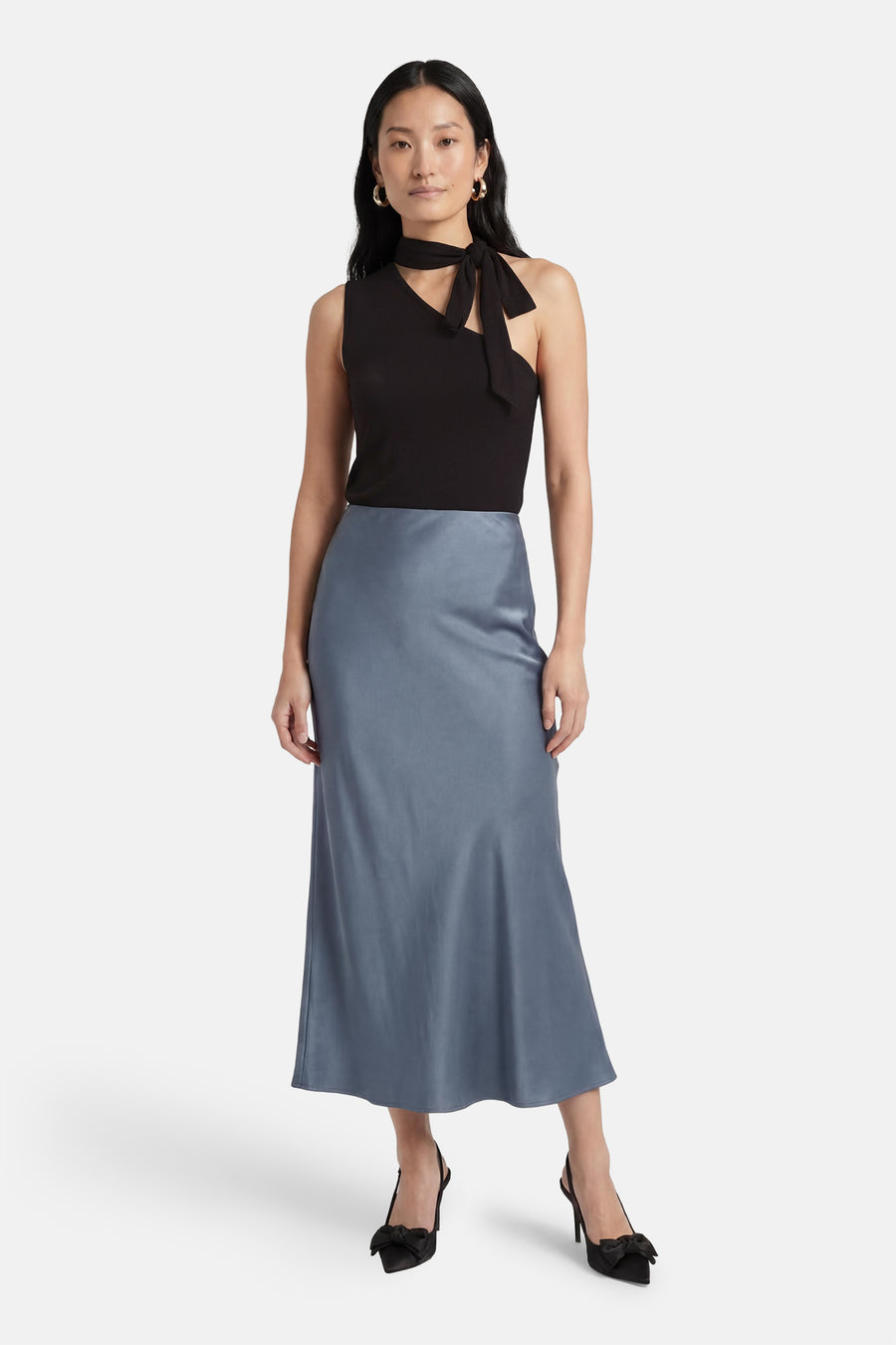 Zwarte geribbelde mouwloze top van JDY met asymmetrische hals en strikdetail, gecombineerd met een satijnen midi-rok.