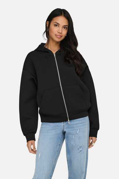 Zwarte sweater met rits van ONLY, met capuchon en zakken, gedragen over een blauwe jeans.