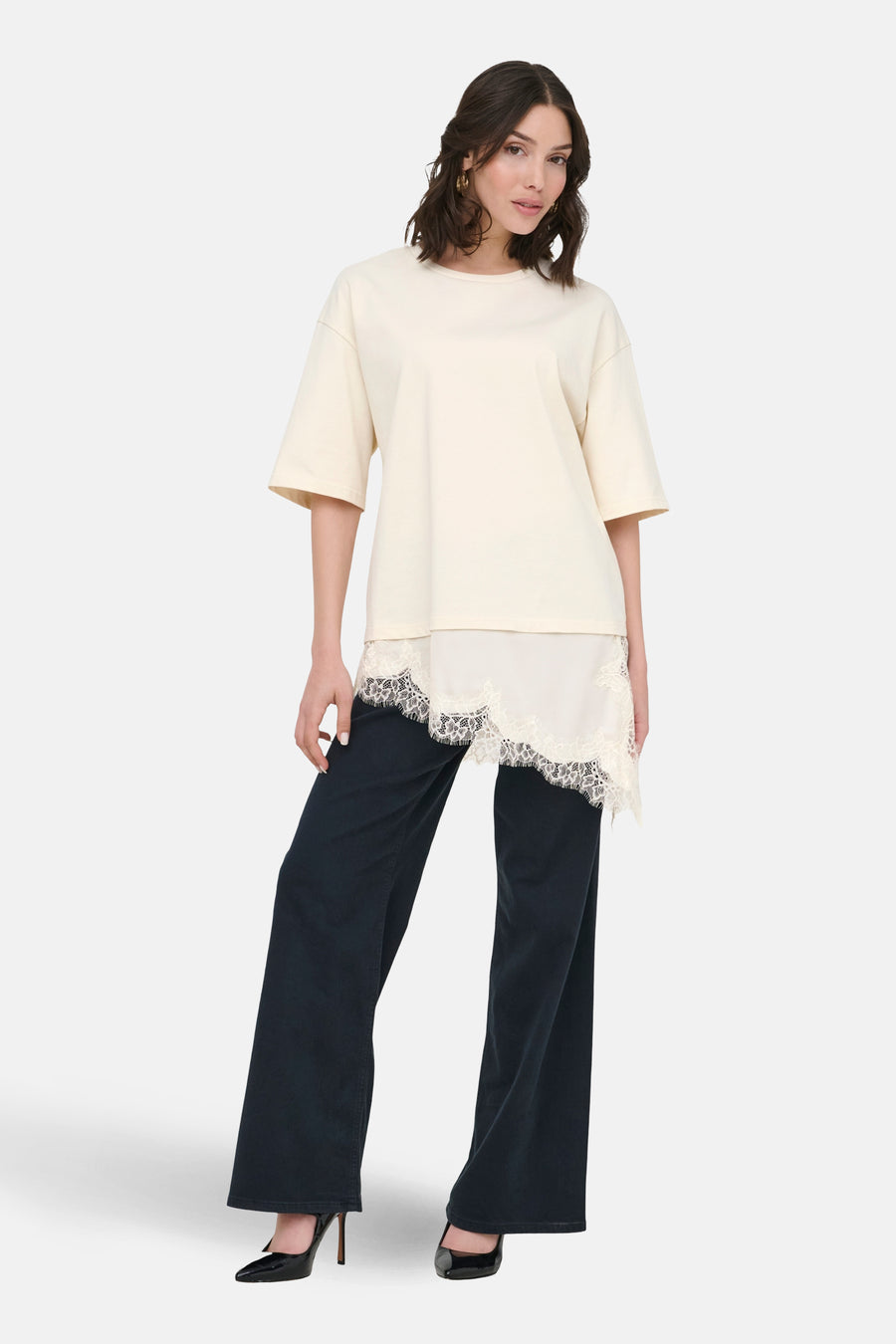 Beige T-shirt met korte mouwen van JDY, met asymmetrische kanten details en gecombineerd met zwarte pantalon en hakken.
