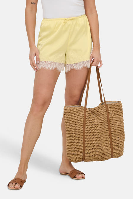 Short en satin effet satiné de ONLY® avec taille élastique, cordon de serrage et bordure en dentelle blanche, porté avec un t-shirt blanc.