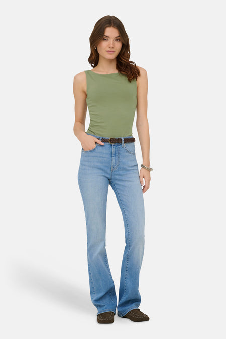 Groene top van ONLY® zonder mouwen met een boothals, gedragen met jeans en bruine mocassins.