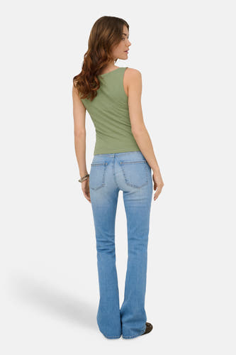 Groene mouwloze top van ONLY®, van achteren gezien op een model met spijkerbroek, zilveren armband en donkere schoenen.