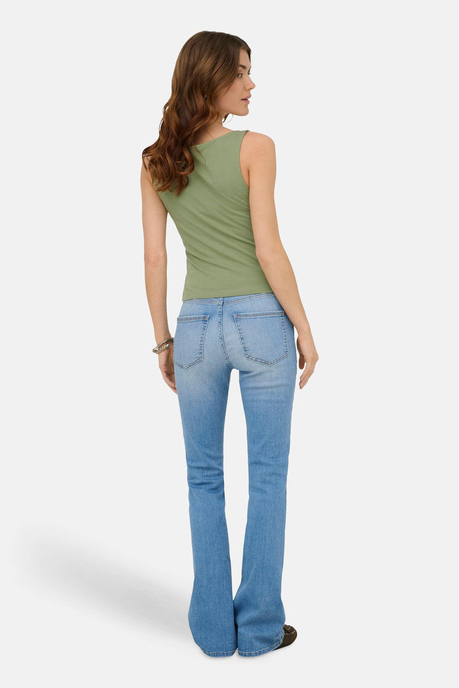 Groene mouwloze top van ONLY®, van achteren gezien op een model met spijkerbroek, zilveren armband en donkere schoenen.